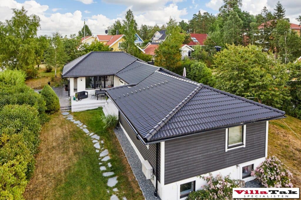 Takomläggning av villa med svarta takpannor