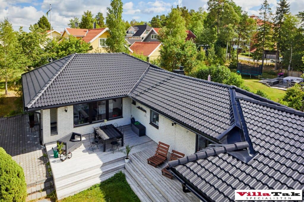Takomläggning av villa med svarta takpannor