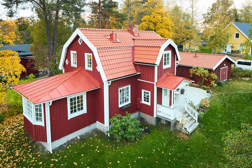 Röd villa med mansardtak med orangea takpannor