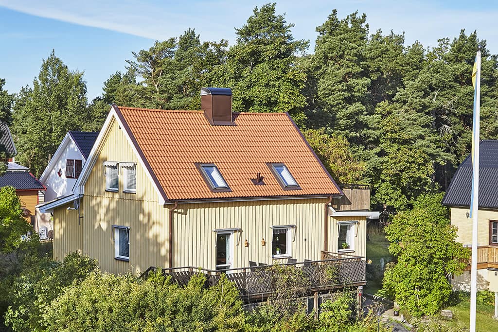Gul villa med orangea takpannor och bruna detaljer
